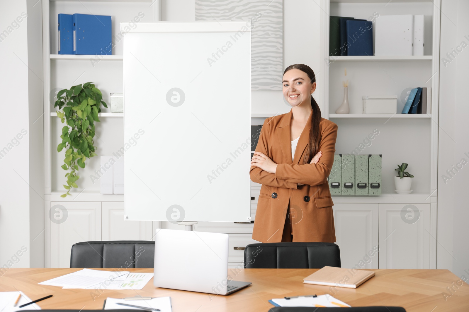 Photo of Happy woman near flip chart in office. Mockup for design