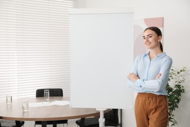 Photo of Happy woman near flip chart in office. Mockup for design