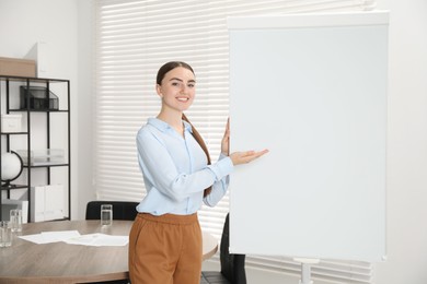 Happy woman near flip chart in office. Mockup for design