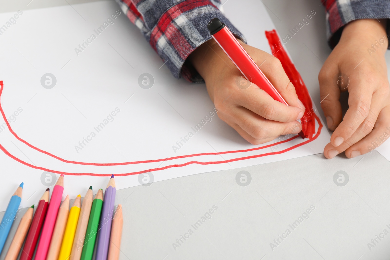 Photo of Boy drawing picture at light table, closeup