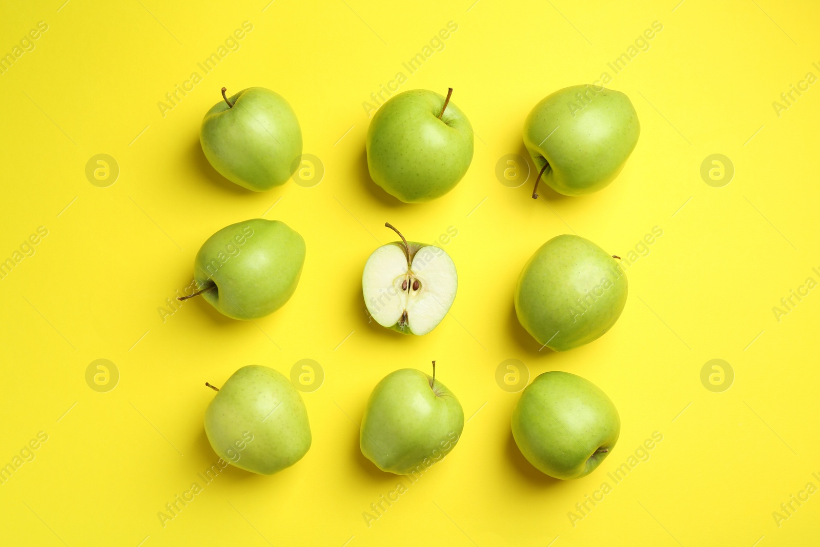 Photo of Flat lay composition with half of apple surrounded by ones on yellow background