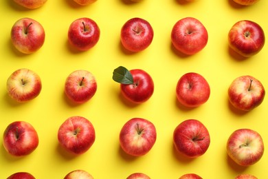 Flat lay composition with many red apples on yellow background