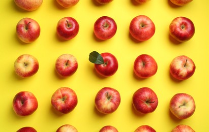 Flat lay composition with many red apples on yellow background