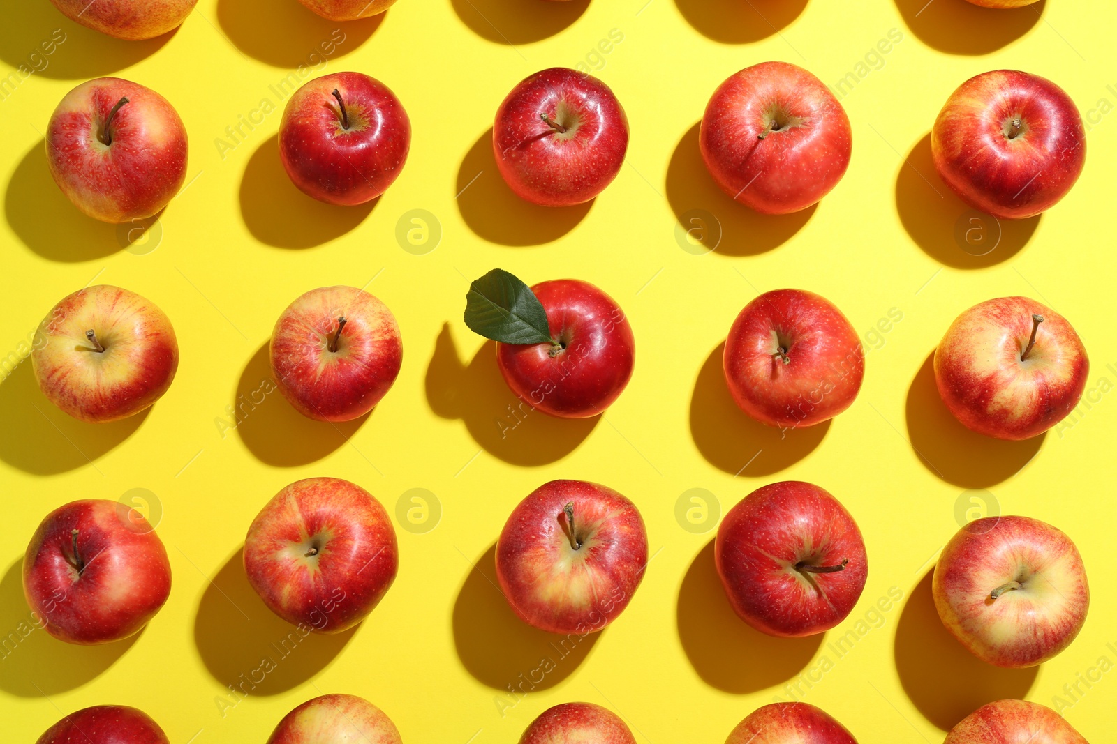 Photo of Flat lay composition with many red apples on yellow background