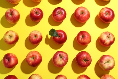 Flat lay composition with many red apples on yellow background