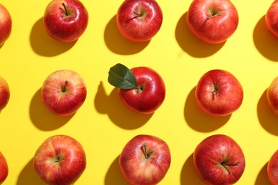 Flat lay composition with many red apples on yellow background