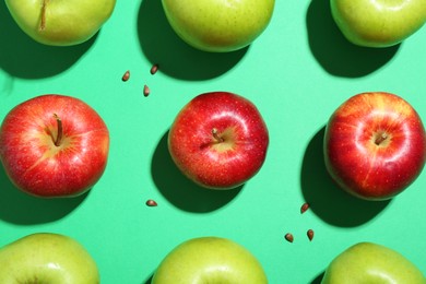 Flat lay composition with different apples and seeds on green background