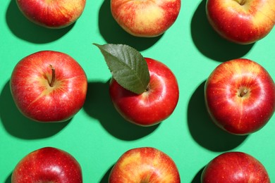 Red apples on green background, flat lay