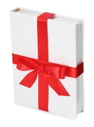 Photo of One book with red ribbon as gift isolated on white