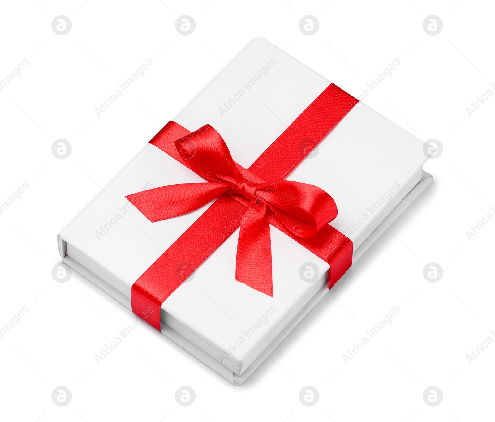 Photo of One book with red ribbon as gift isolated on white