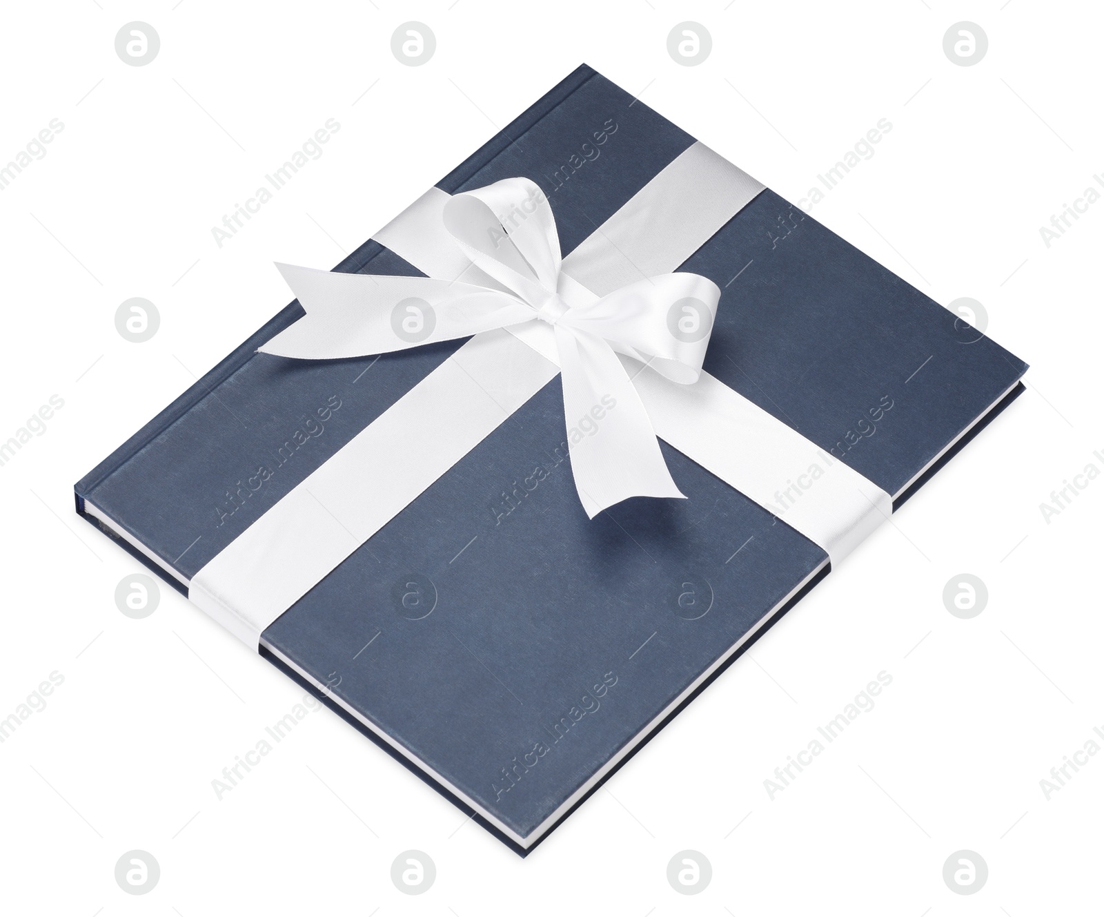 Photo of One book with silk ribbon as gift isolated on white