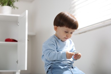 Photo of Little boy with pills at home. Child in danger