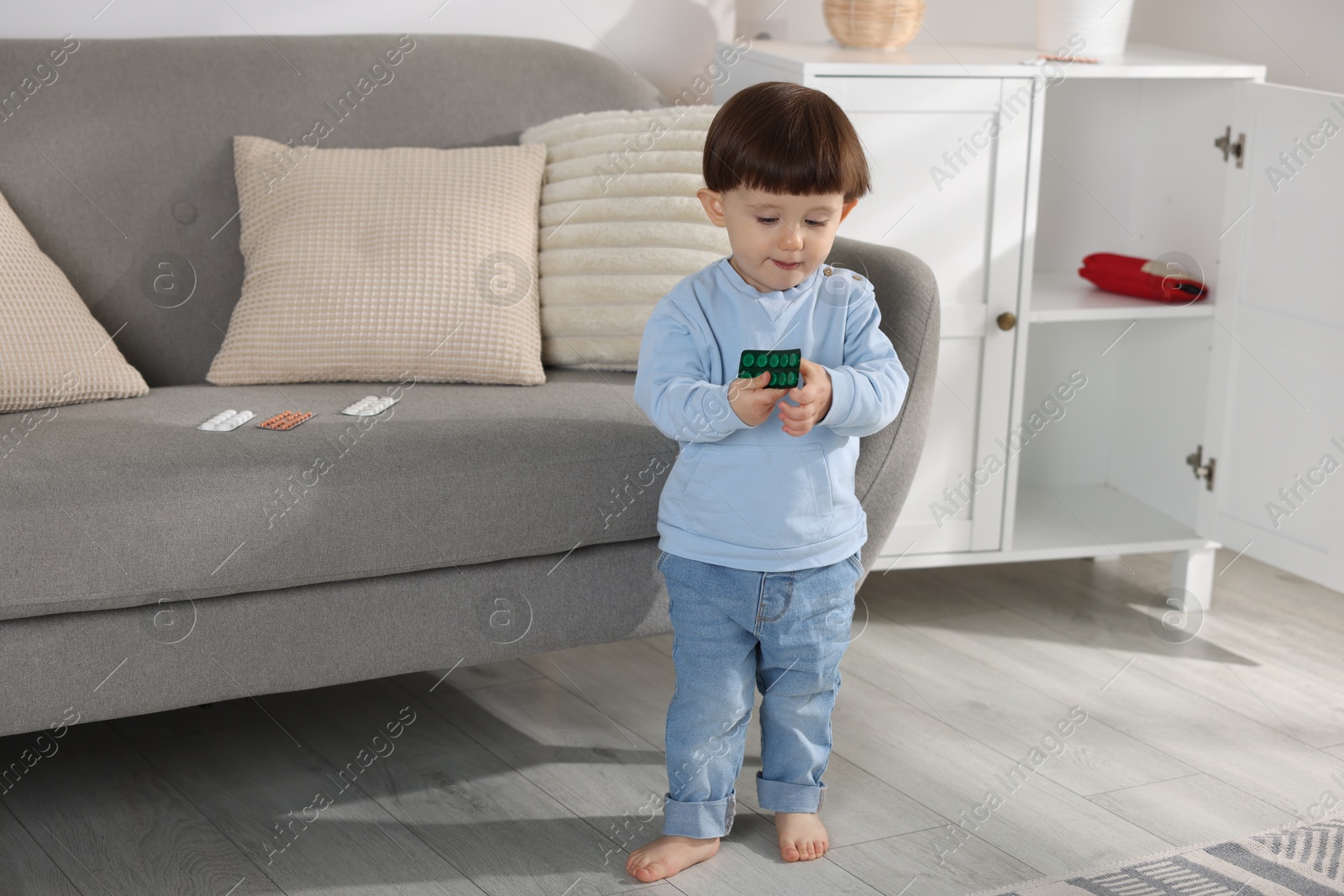 Photo of Little boy with pills at home. Child in danger