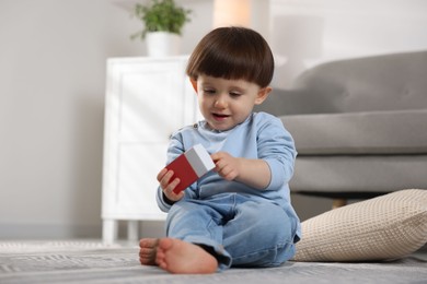 Photo of Little boy playing with matchbox at home. Child in danger