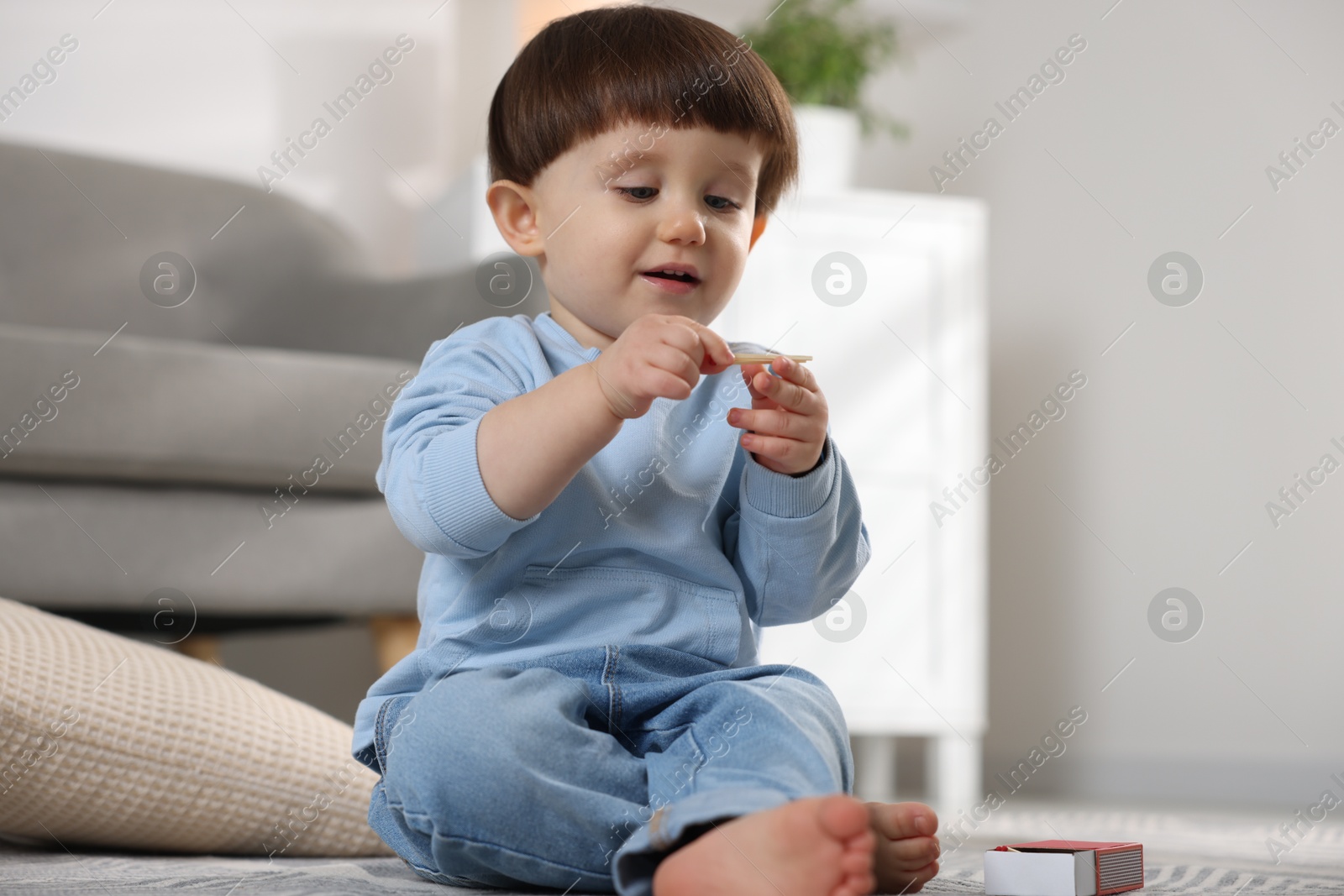 Photo of Little boy playing with matches at home. Child in danger