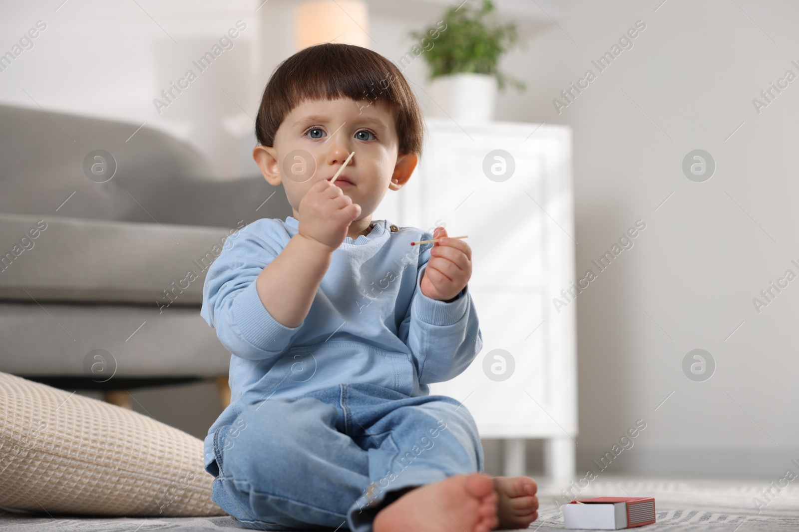 Photo of Little boy playing with matches at home. Child in danger