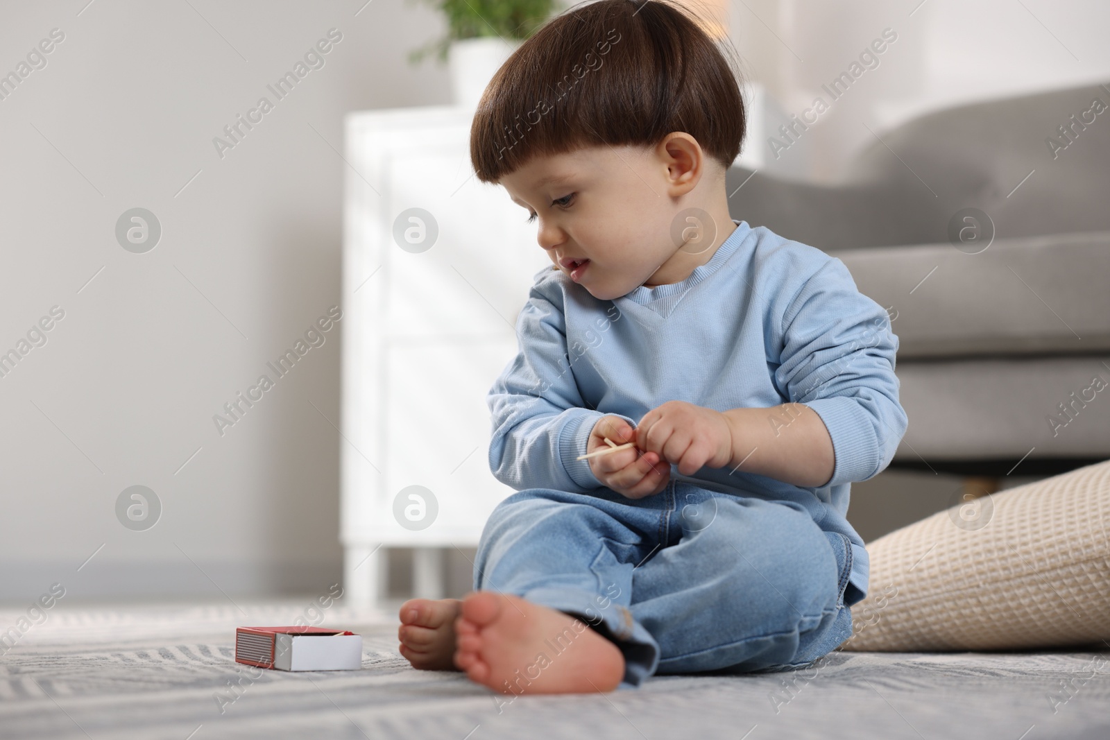 Photo of Little boy playing with matches at home. Child in danger