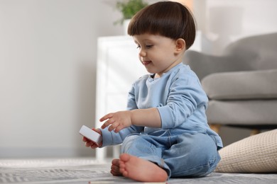 Photo of Little boy playing with matchbox at home, space for text. Child in danger