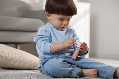 Photo of Little boy playing with match at home. Child in danger