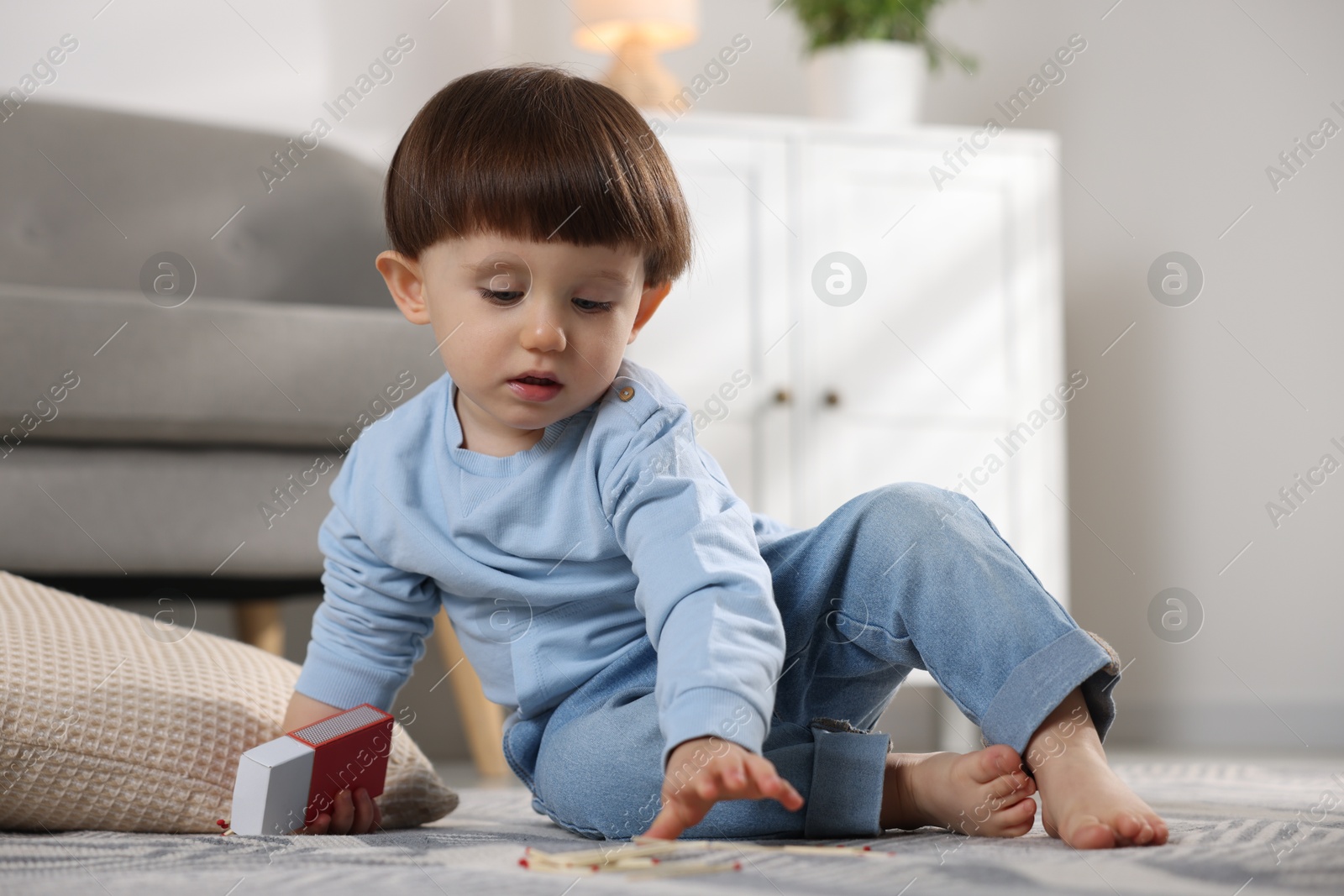 Photo of Little boy playing with matches at home. Child in danger