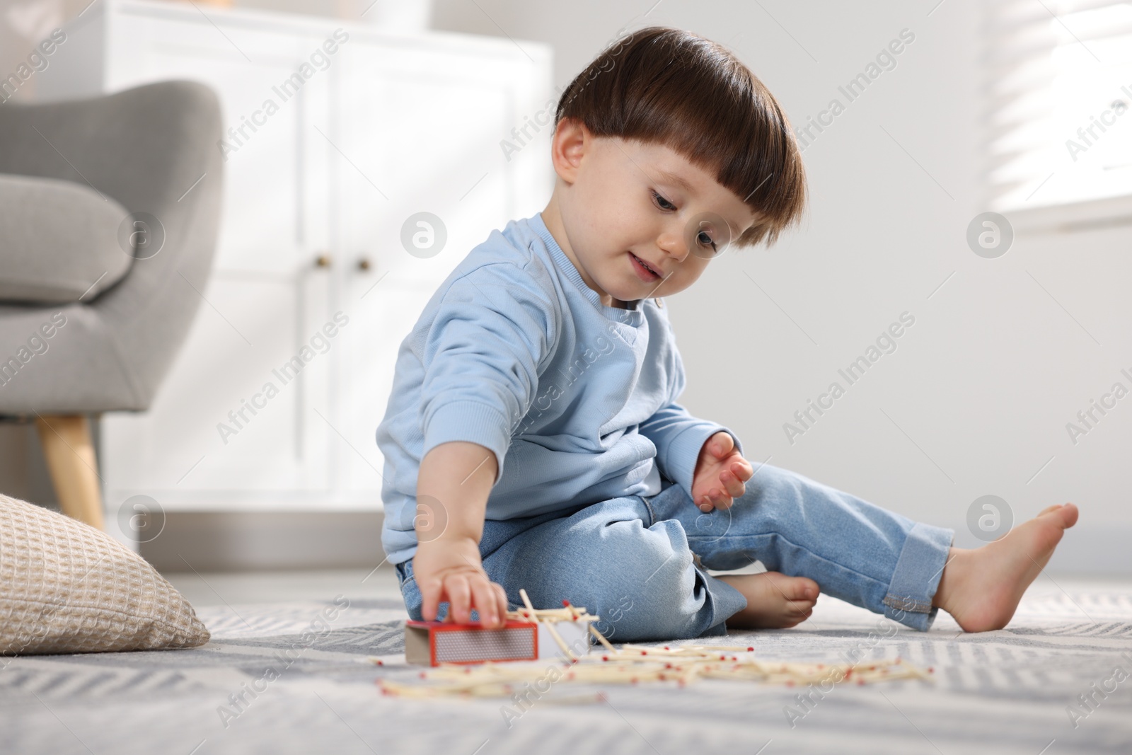 Photo of Little boy playing with matches at home. Child in danger