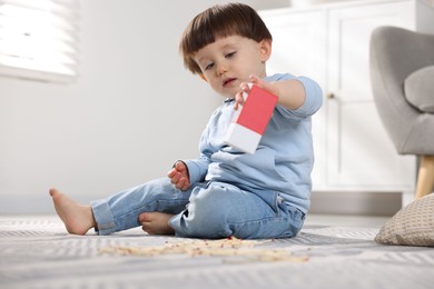 Photo of Little boy playing with matchbox at home. Child in danger