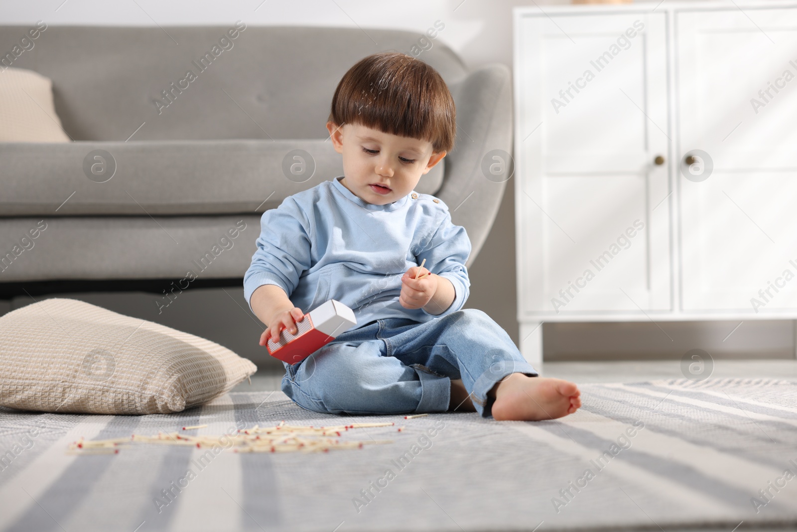 Photo of Little boy playing with matches at home. Child in danger