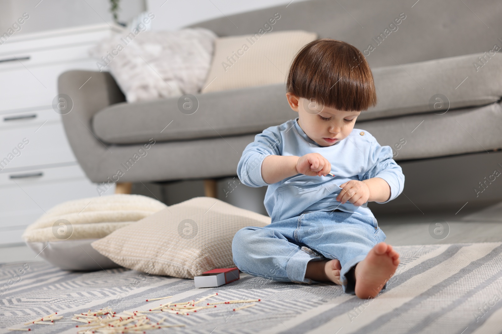 Photo of Little boy playing with matches at home. Child in danger