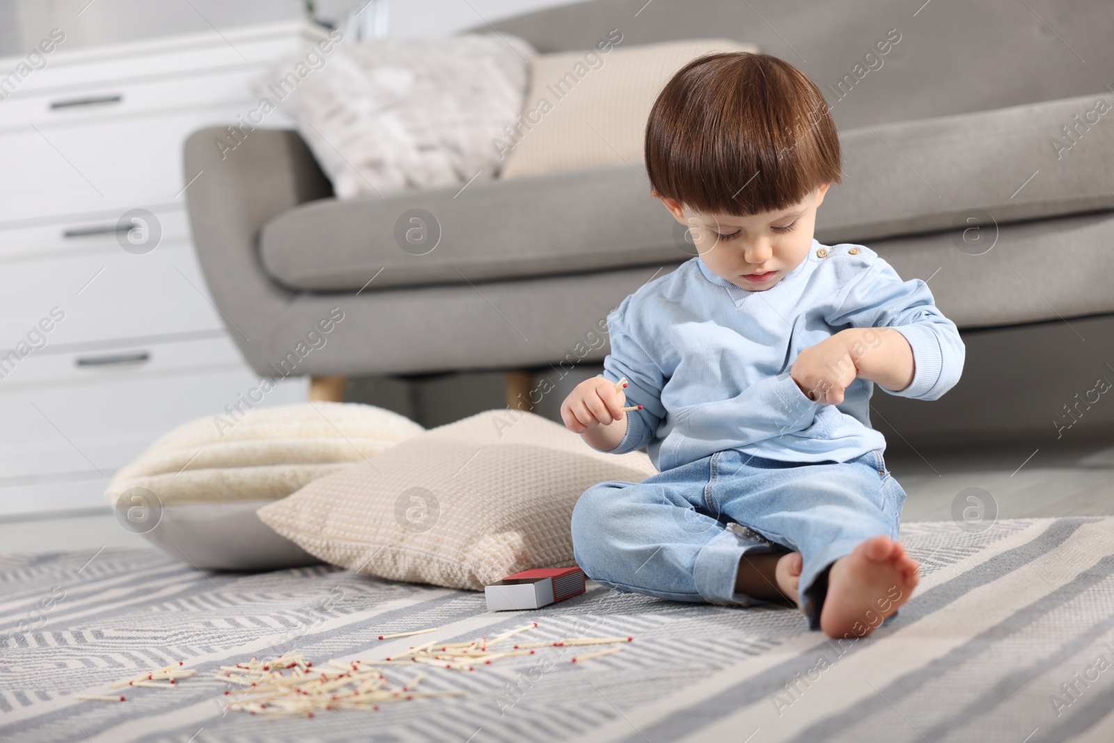 Photo of Little boy playing with matches at home. Child in danger