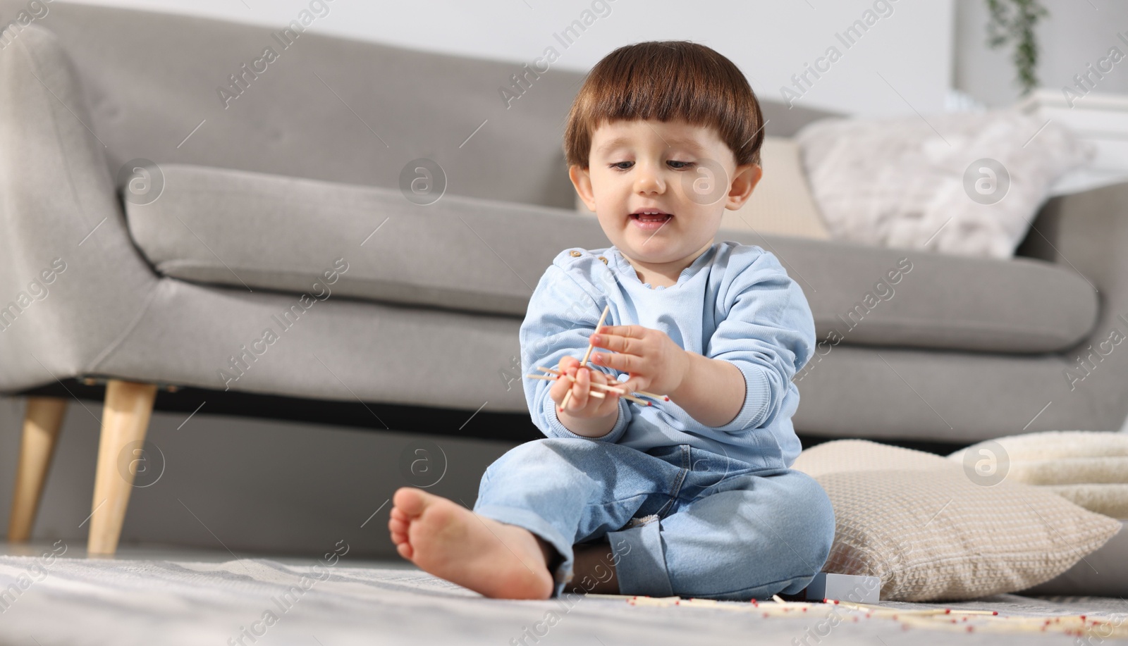 Photo of Little boy playing with matches at home. Child in danger