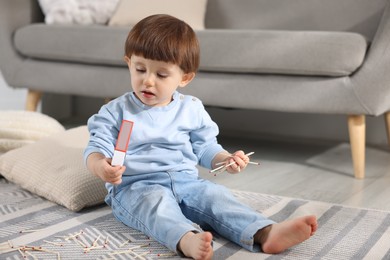 Photo of Little boy playing with matches at home. Child in danger