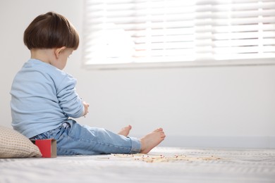 Photo of Little boy playing with matches at home, space for text. Child in danger