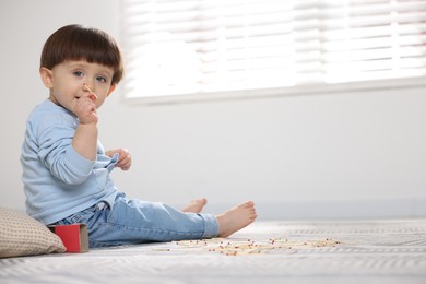 Photo of Little boy playing with matches at home, space for text. Child in danger