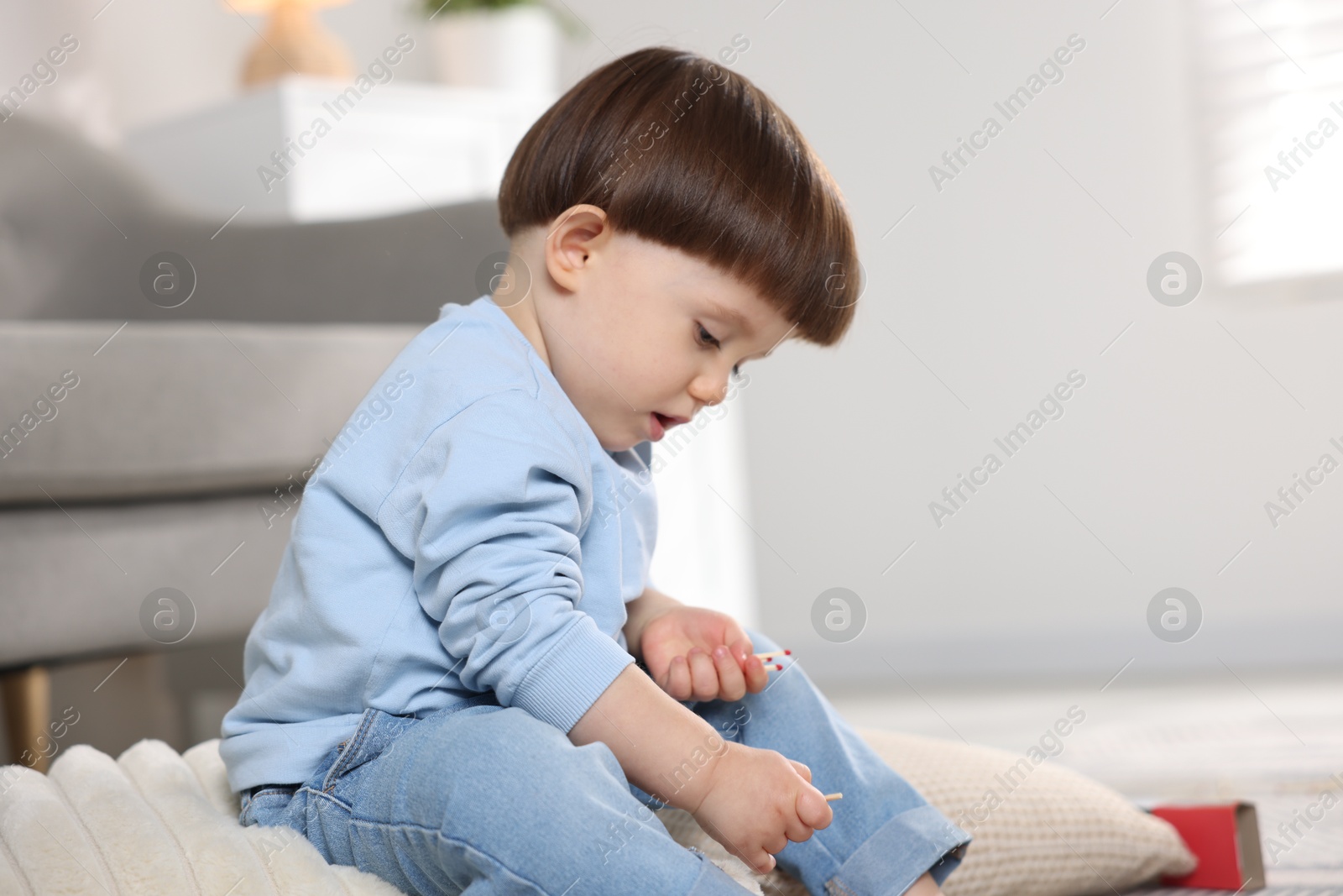 Photo of Little boy playing with matches at home. Child in danger