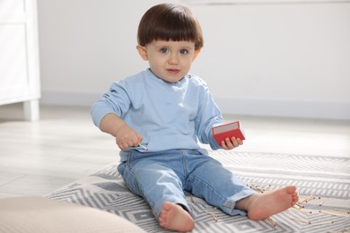 Photo of Little boy playing with matchbox at home. Child in danger