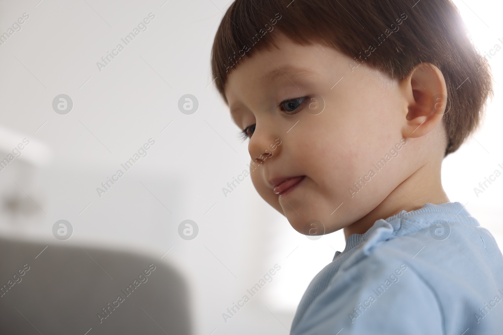 Photo of Portrait of cute little boy on blurred background, closeup. Space for text