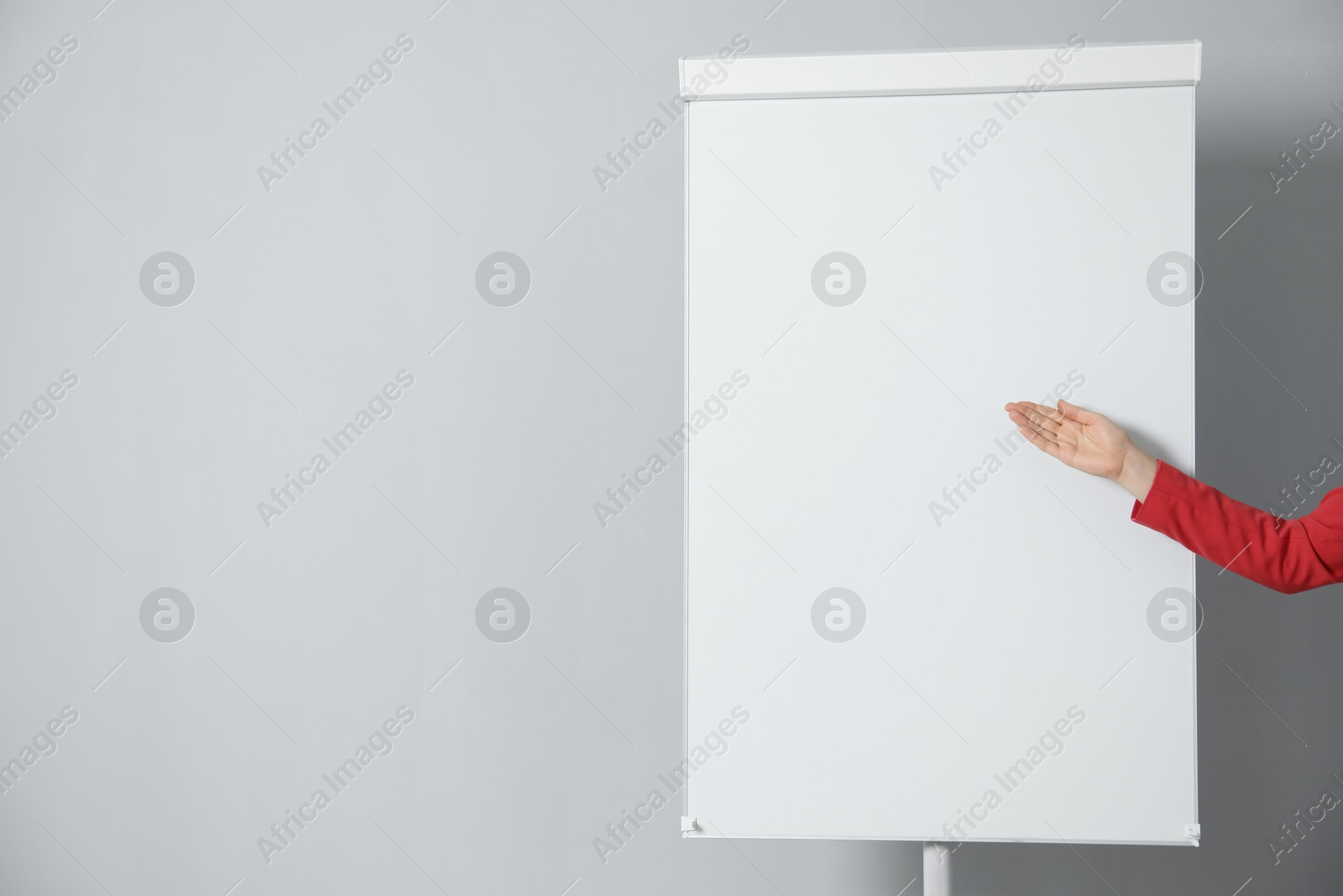 Photo of Woman near flip chart on grey background, closeup. Mockup for design