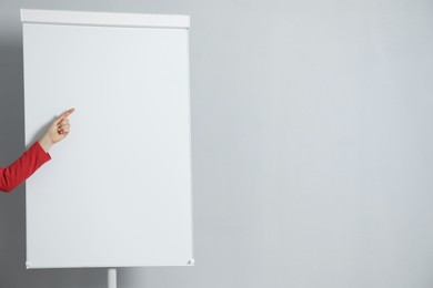 Photo of Woman near flip chart on grey background, closeup. Mockup for design