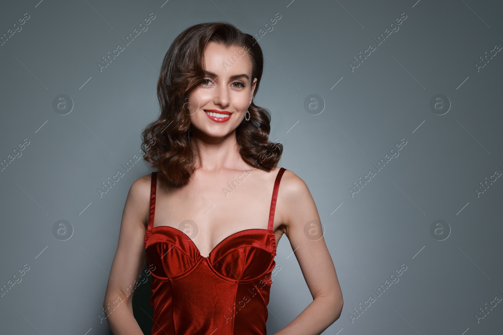 Photo of Portrait of smiling woman with perfect makeup on grey background. Space for text