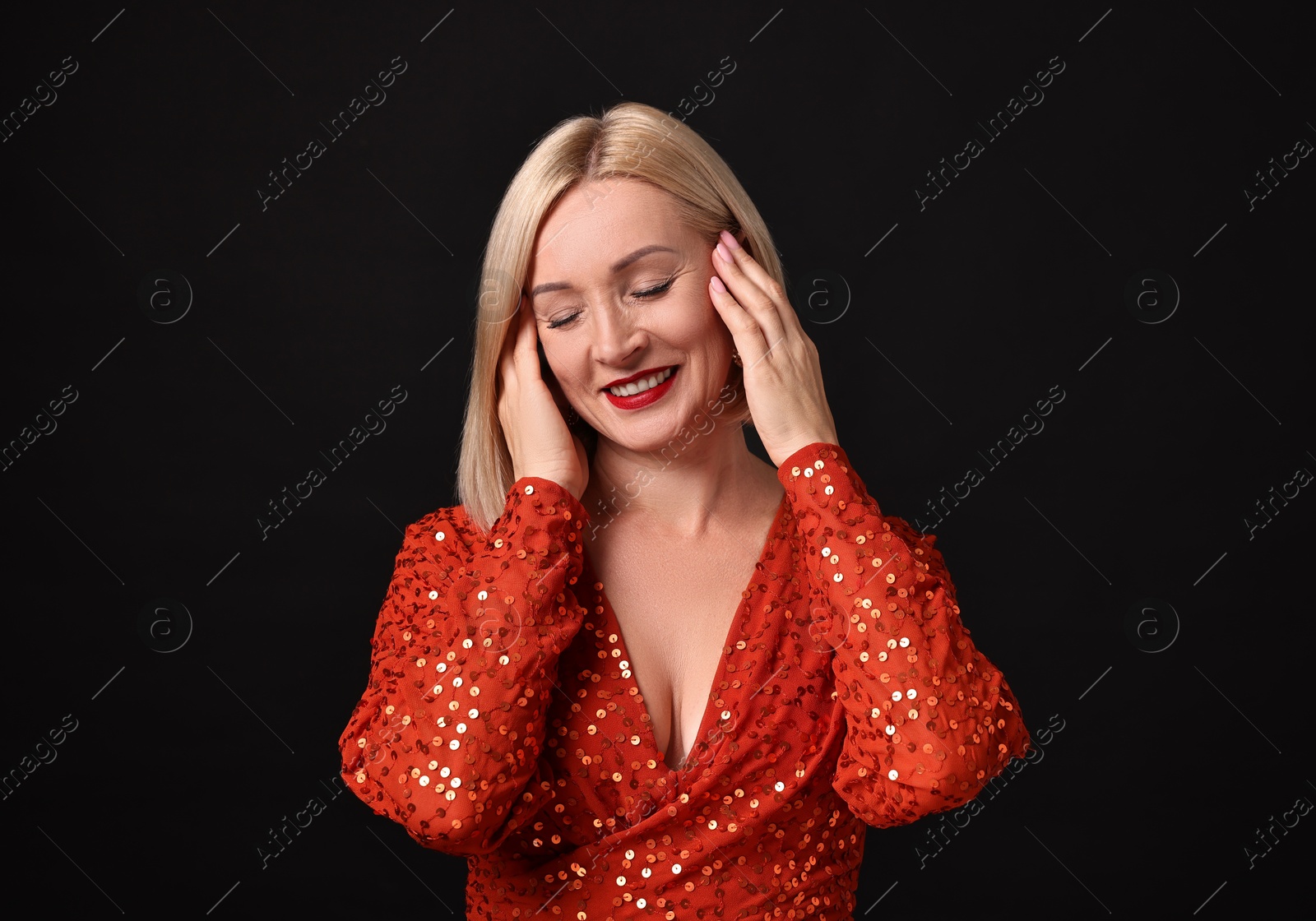 Photo of Smiling woman with perfect makeup on black background