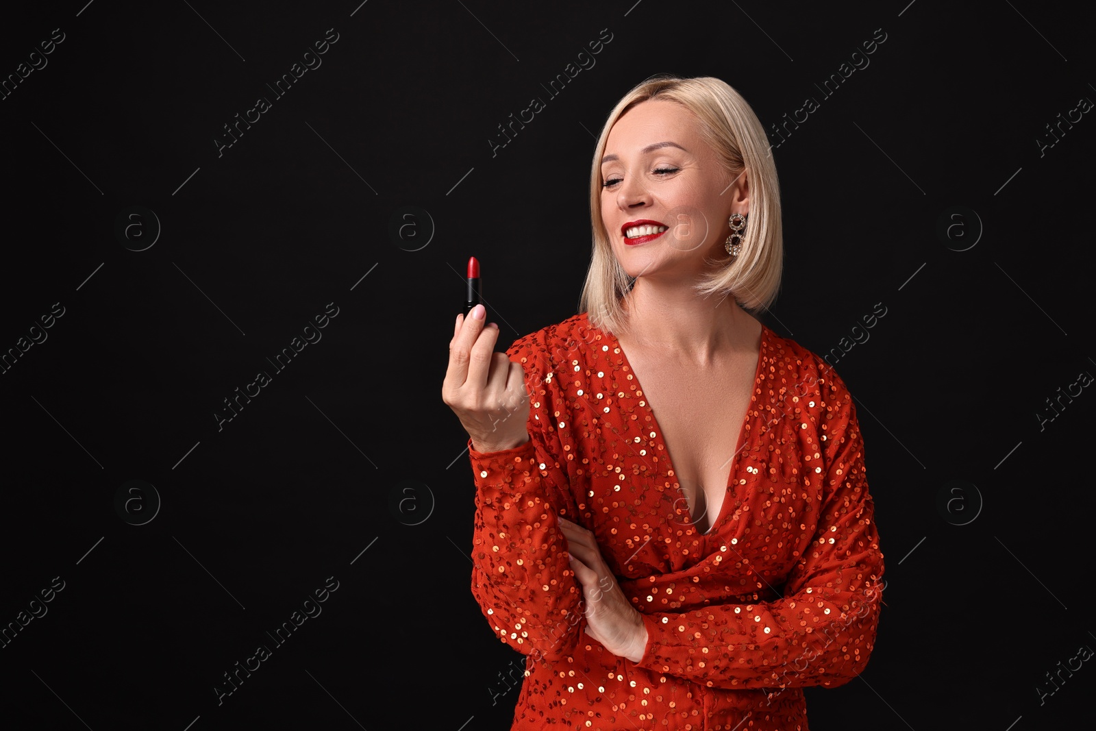 Photo of Smiling woman with red lipstick on black background. Space for text