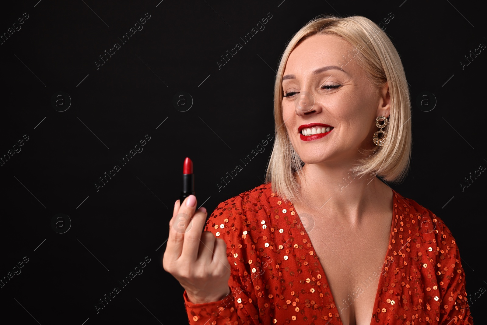 Photo of Smiling woman with red lipstick on black background. Space for text