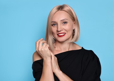 Photo of Smiling woman with perfect makeup on light blue background