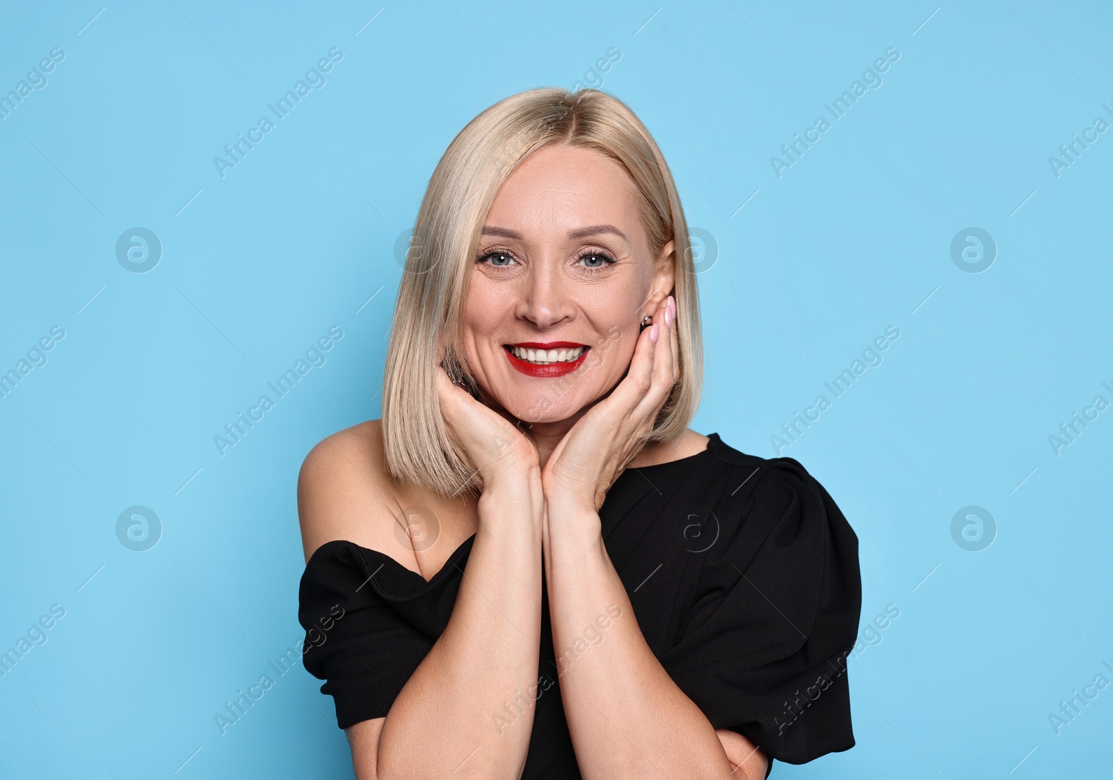 Photo of Smiling woman with perfect makeup on light blue background