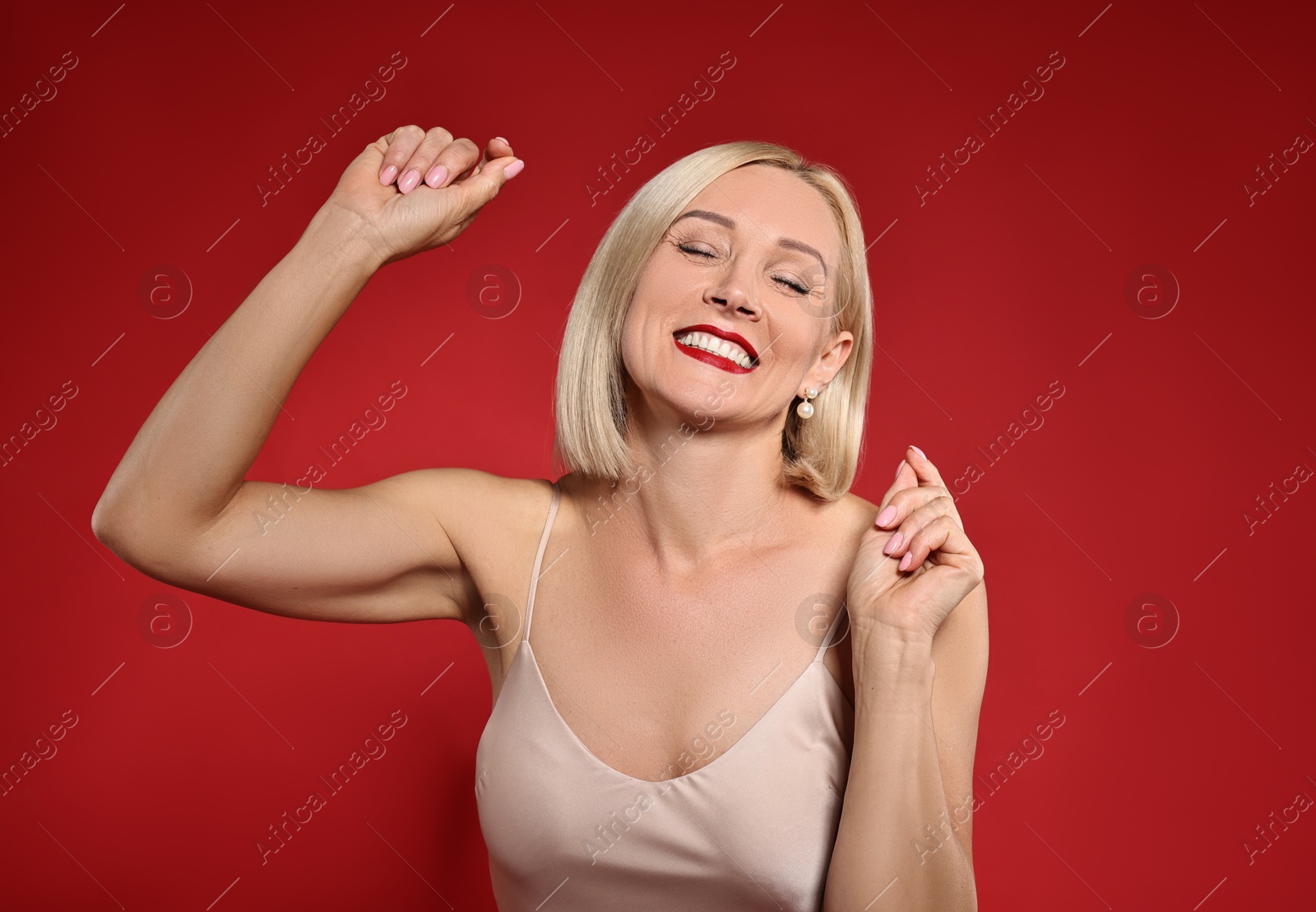 Photo of Smiling woman with perfect makeup on red background