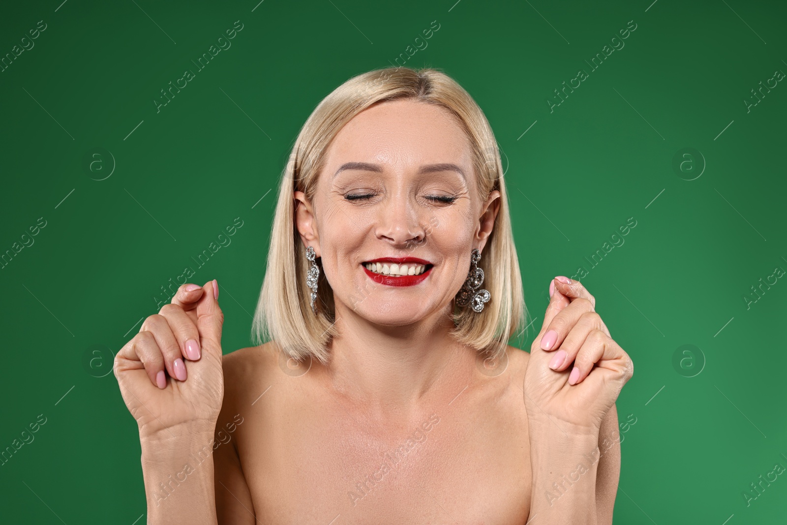 Photo of Smiling woman with perfect makeup on green background