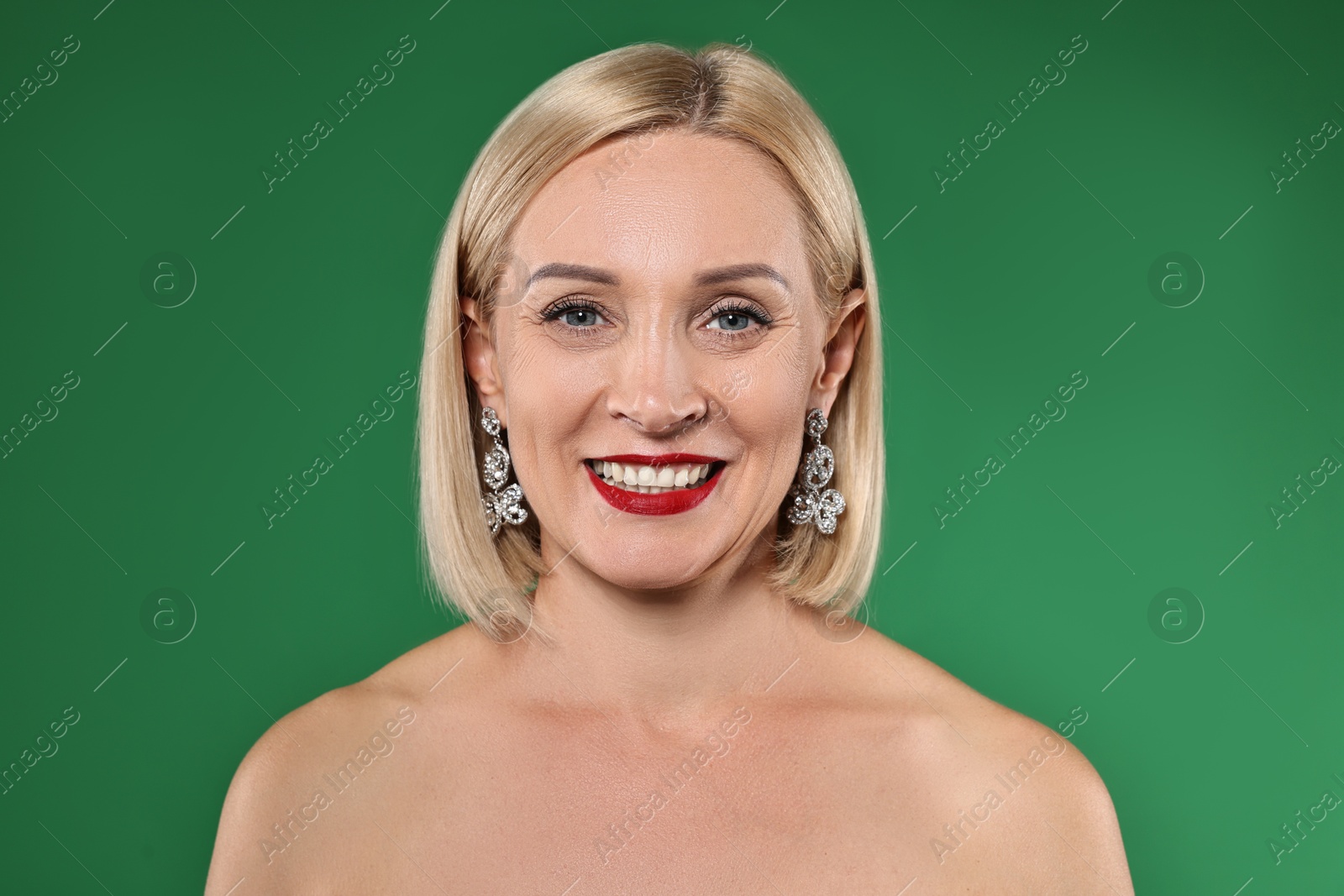 Photo of Smiling woman with perfect makeup on green background