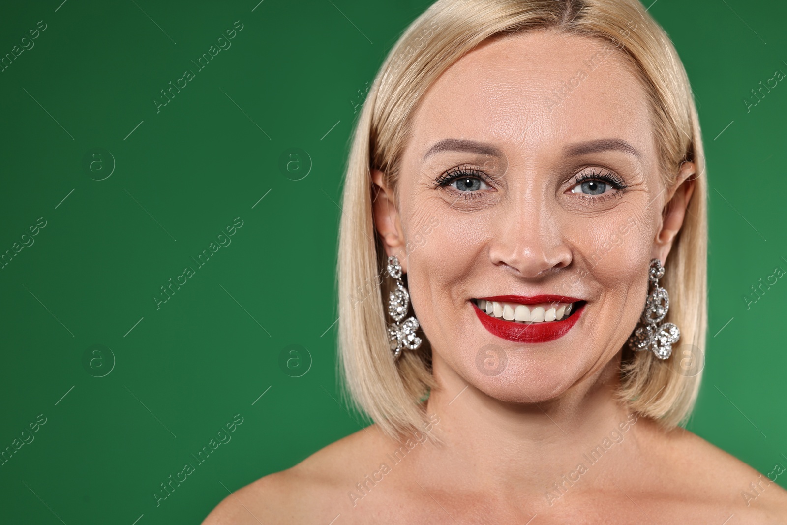 Photo of Smiling woman with perfect makeup on green background. Space for text