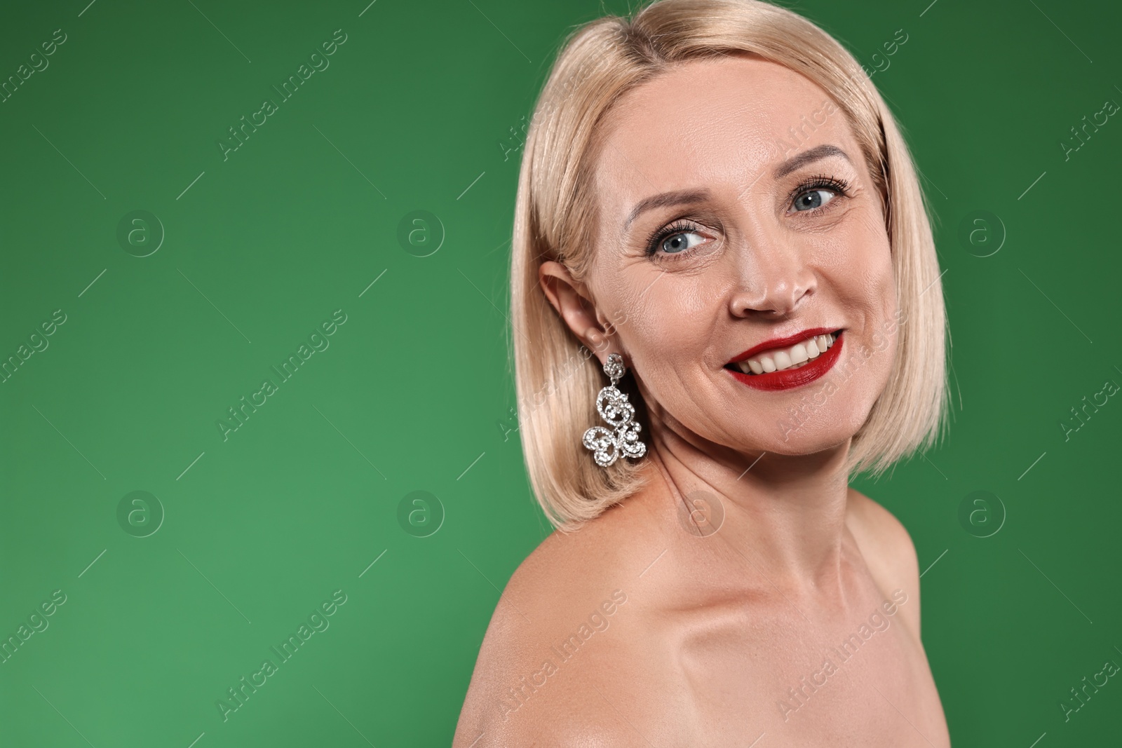 Photo of Smiling woman with perfect makeup on green background. Space for text