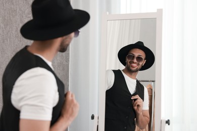 Photo of Smiling man looking at mirror at home